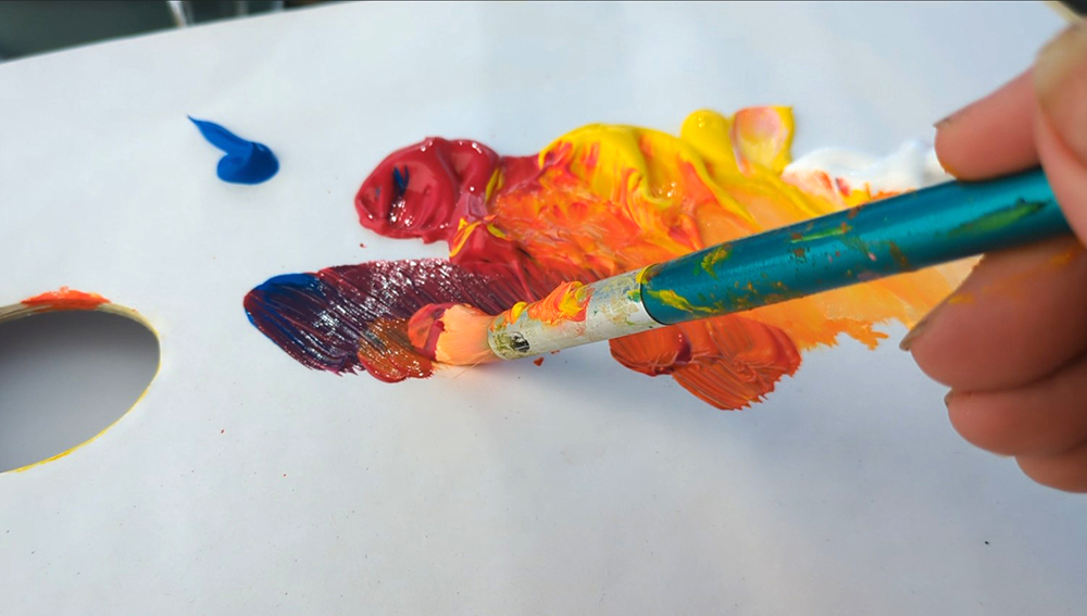 A paintbrush mixing acrylic paint